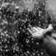 Hand im prasselnden Regen ohne Regenschirm